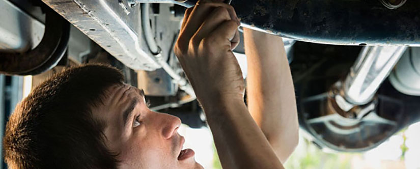 Mechanic servicing underneath of a car