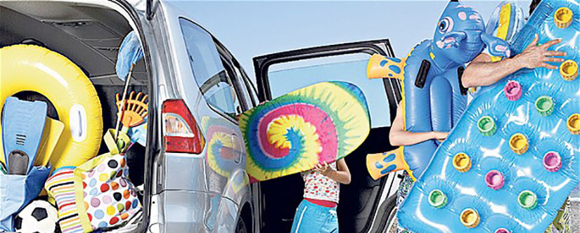 Family getting out of car with rafters for the beach