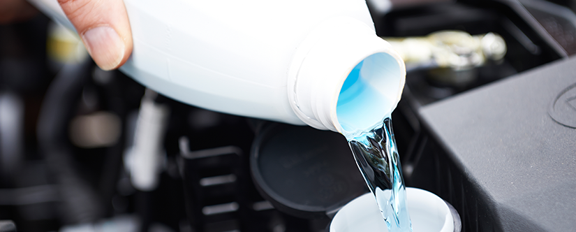Pouring blue fluid into car engine