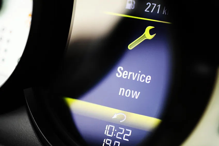 a dashboard computer shows a spanner icon and the message ‘service now’.